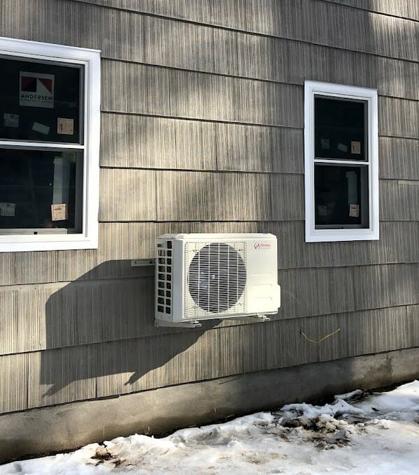 Norton HVAC unit mounted on wall with snow covered ground